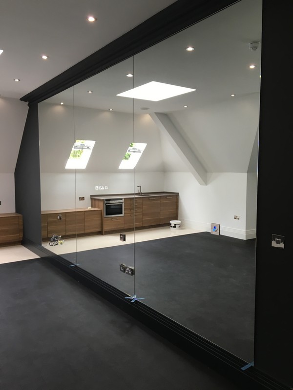 Frameless glass partition in loft conversion by Kilburn glaziers
